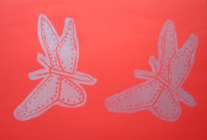Mathias fjäril - vit färg på rött papper.